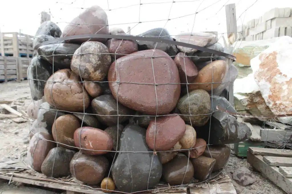 Dry creek bed landscaping channel with river rock in a McKinney yard